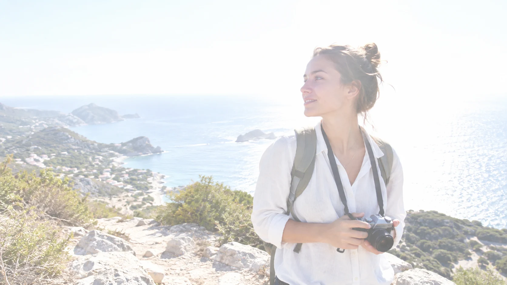 Overexposed traveler at a coastal viewpoint before correction