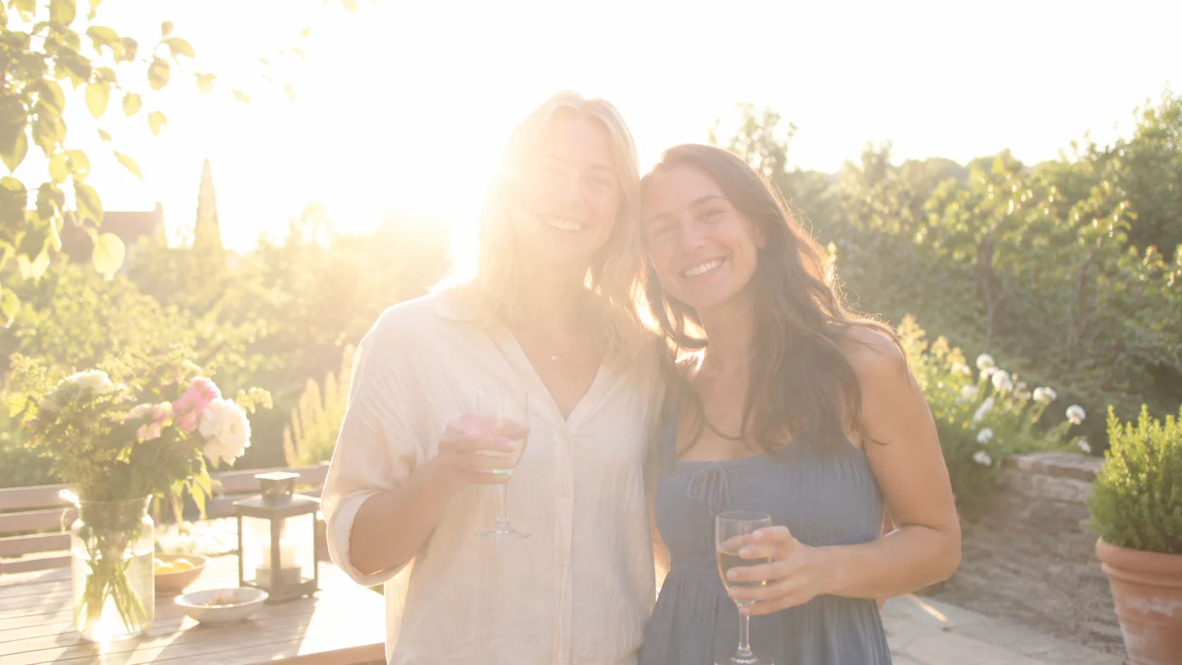 Two friends at a bright garden celebration before correction