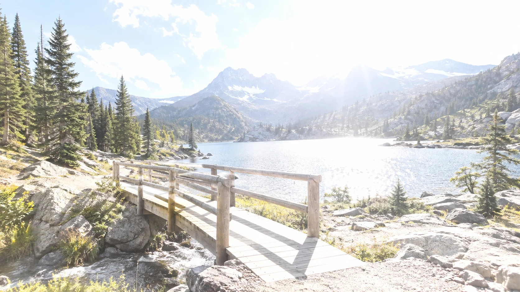 Overexposed mountain lake footbridge before correction